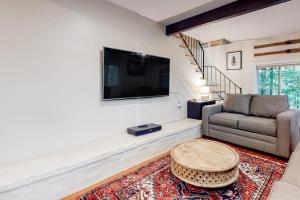 a living room with a couch and a flat screen tv at Gunstock Getaway in Gilford