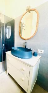 a bathroom with a blue sink and a mirror at Casa Peloro in Torre Faro
