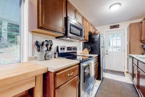 a kitchen with a stove and a microwave at Gunstock Getaway in Gilford