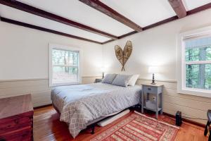 a bedroom with a bed and two windows at Gunstock Getaway in Gilford