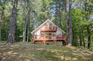 a house with a deck in the woods at Gunstock Getaway in Gilford