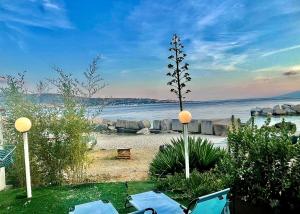 a view of a beach with chairs and the water at Casa Peloro in Torre Faro