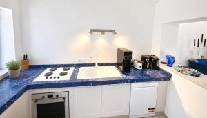 a kitchen with a blue counter top and a sink at Casa Peloro in Torre Faro