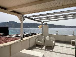a porch with chairs and a view of the water at Casa Peloro in Torre Faro