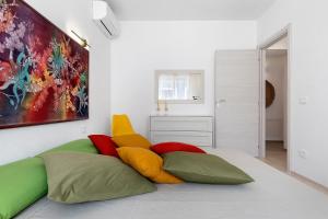 a bedroom with a bed with colorful pillows on it at Lu Furru Apartments in Telti