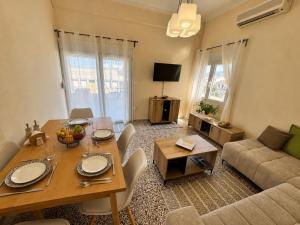 a living room with a table and a couch at Central Mytilene City-View Apartment for 7 in Mytilene