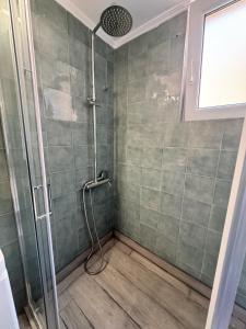 a shower with a glass door in a bathroom at Central Mytilene City-View Apartment for 7 in Mytilene +17 photos