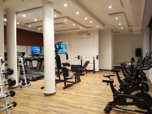 a gym with a lot of treadmills and machines at Logements Majeo in Bikondo