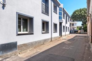 an empty street next to a white building at Lu Furru Apartments in Telti