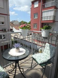 a balcony with a table and chairs on a balcony at Sirmijum Hause II in Sremska Mitrovica
