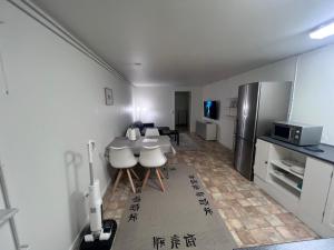 a kitchen with a table and chairs and a refrigerator at Arctic Hostel Apartment in Qaqortoq