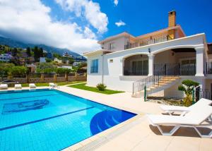 a villa with a swimming pool and a house at Villa Tiara by HolidayKeys in Kyrenia
