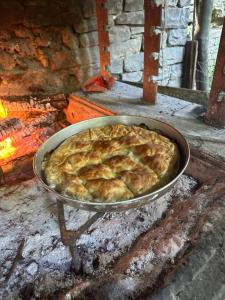 a pie in a pan in a oven at Dafinat in Bogovë