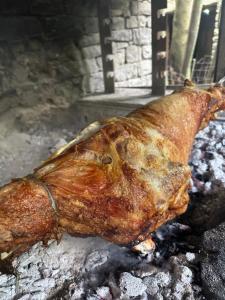 a piece of meat cooking on a grill at Dafinat in Bogovë +83 photos