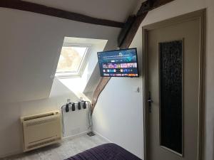 a bedroom with a bed and a tv on the wall at Le Jaonnet in Nabirat