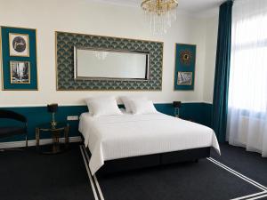 a bedroom with a bed and a painting on the wall at Willa Ingeborg in Międzyzdroje