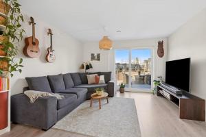 a living room with a gray couch and a tv at Three bedrooms house in Holmestrand