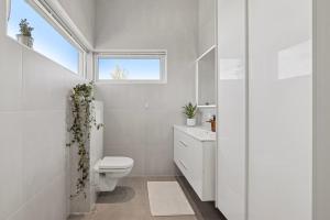 a white bathroom with a toilet and a window at Three bedrooms house in Holmestrand +7 photos