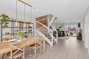 a dining room with a table and a staircase at Three bedrooms house in Holmestrand