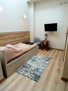 a bedroom with a bed and a flat screen tv at Hotelik Kościerzyna in Kościerzyna