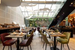 a restaurant with tables and chairs and a dinosaur on the ceiling at Hôtel B55 in Paris