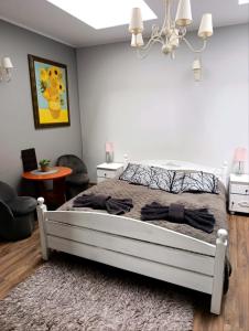 a bedroom with a bed and a chandelier at Hotelik Kościerzyna in Kościerzyna