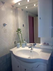 a bathroom with a sink and a mirror at Apartment Michalis by the Sea in Artemida