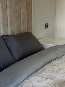 a bed with a blue pillow on top of it at Malibo Central Apartments in Baku