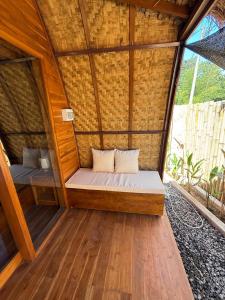 a small room with a bed in a bamboo house at Kokonut Resor Amed in Amed