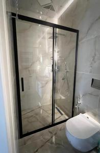 a bathroom with a glass shower with a toilet at Malibo Central Apartments in Baku +8 photos