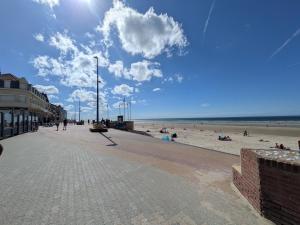 a beach with people on the sand and the ocean at Maison La Petite Pause in Bray-Dunes