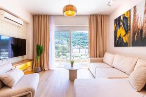 a living room with a couch and a tv at Dhermi's Icon Big 1BR Apt 6 in Dhërmi