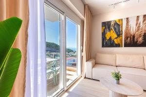 a living room with a couch and a large window at Dhermi's Icon Big 1BR Apt 6 in Dhërmi
