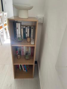 a book shelf with books and a vase on it at Maison La Petite Pause in Bray-Dunes