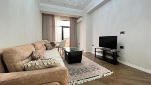 a living room with a couch and a flat screen tv at Malibo Central Apartments in Baku