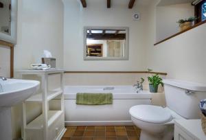 a bathroom with a tub and a toilet and a sink at Mowhay Barn in Torpoint +17 photos