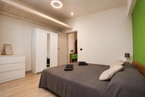 a bedroom with a large bed and a green wall at Casa della Salvia con Piscina, relax in campagna vicino al mare in Santa Croce Camerina