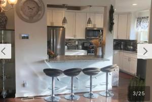 a kitchen with four bar stools in front of a counter at Naomi BED and BREAKFAST in Parkville +9 photos