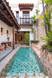 a swimming pool in the courtyard of a house at Hotel Boutique Santo Toribio in Cartagena de Indias