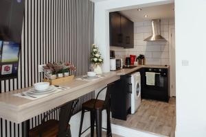 a kitchen with a counter and a dishwasher at The Snug by JS Apartments in Blackburn