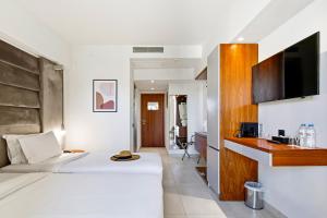 a hotel room with a bed and a tv at DOM Boutique Hotel in Heraklio