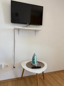 a table with a remote control and a tv on a wall at Power view in Bečići