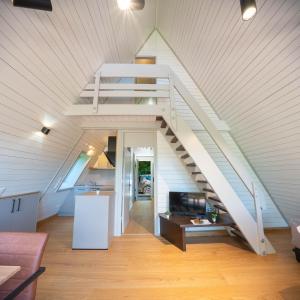 a living room with a staircase in a house at Ferienhäuser Campingplatz in Kinding