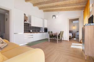 a kitchen and living room with a table and chairs at Lu Furru Apartments in Telti