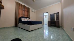 a living room with a bed and a television at Furaha House in Chukwani