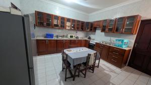 a kitchen with wooden cabinets and a table in it at Furaha House in Chukwani