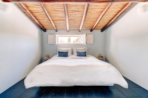 a bedroom with a white bed with a window at Casa Porta Azul in Boliqueime +32 photos