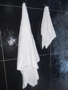 two white towels hanging on a tiled floor at Salo in Georgetown