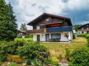 a house with a wooden roof and a yard at Ferienwohnung Spatzennest in Arrach