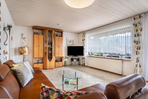 a living room with a couch and a tv at Ferienwohnung Spatzennest in Arrach